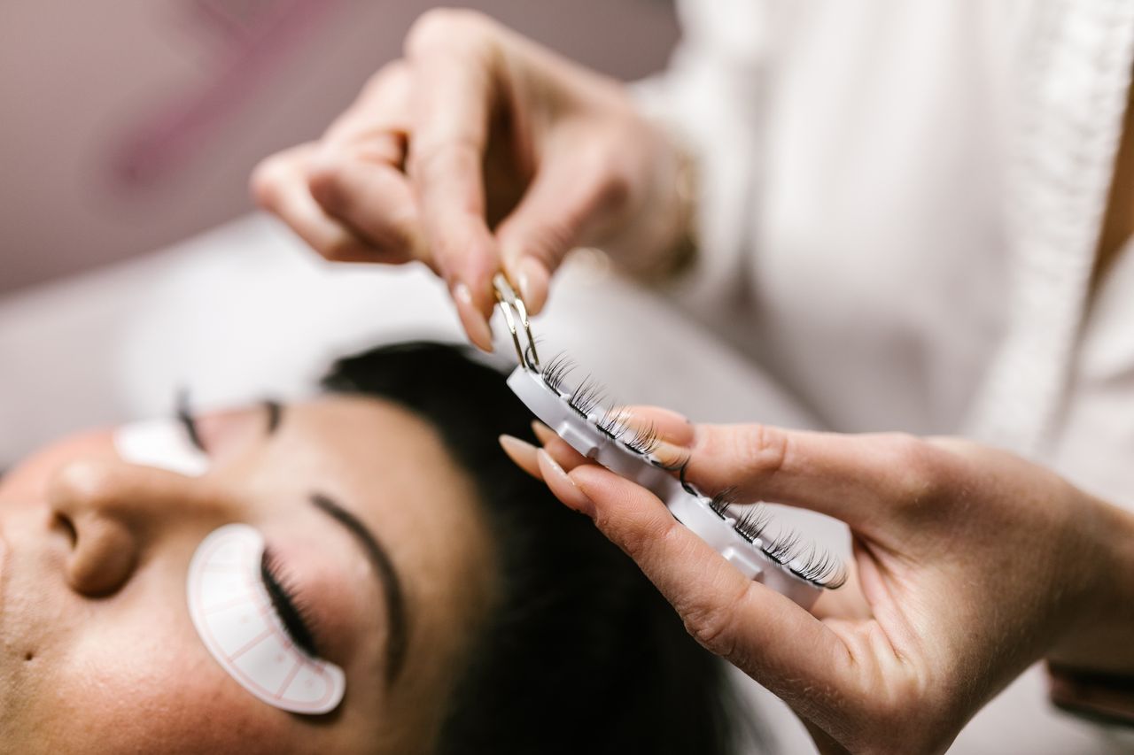 Detailed view of eyelash extension procedure in salon setting.